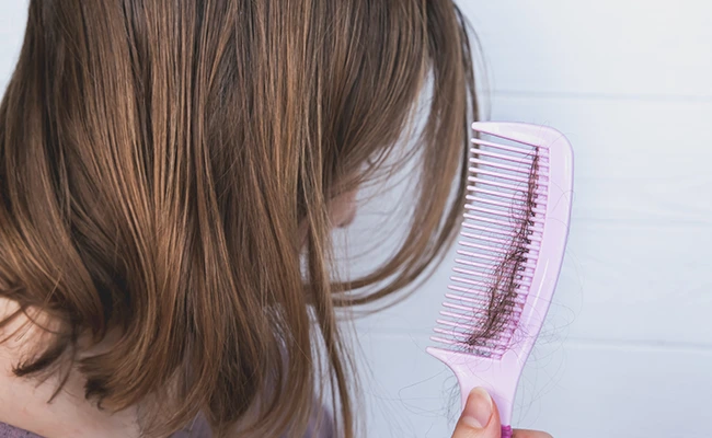 Εποχική τριχόπτωση σε γυναίκα που βλέπει τρίχες στη χτένα